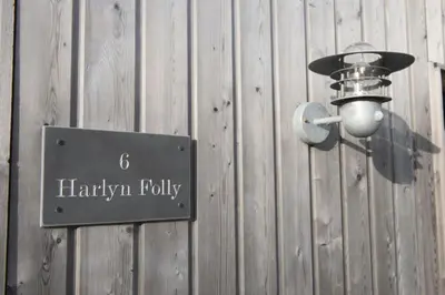 a sign on a wooden wall with a light on it at Harlyn Folly, Apartment 6, Harlyn in St Merryn