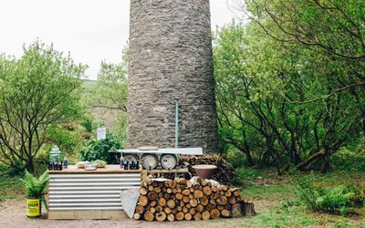 a stack of logs in front of a large chimney at Kudhva 4 in Treknow