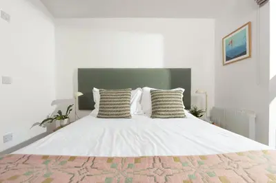 a bedroom with a large white bed with two pillows at 71 Una, Carbis Bay in Carbis Bay