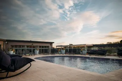 a swimming pool with chairs and a building at 71 Una, Carbis Bay in Carbis Bay