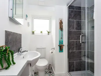 a bathroom with a toilet and a sink and a shower at The Loft in Porthleven