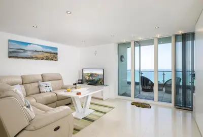 a living room with a couch and a table at 25 Rocklands in Newquay in Newquay
