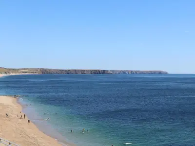 a group of people in the water at the beach at Teg in Helston