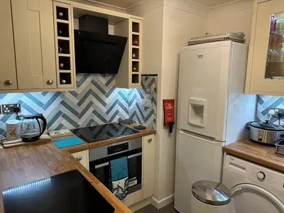 a kitchen with a white refrigerator and a stove at Penolva Beach Side Apartment in Perranporth
