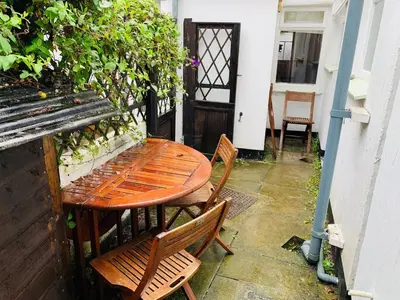 a wooden table and chairs sitting on a patio at Maypole Cottages - No 12 Broad Street in Padstow