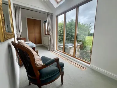 a living room with a chair and a large window at Trelean Lodge in Leedstown