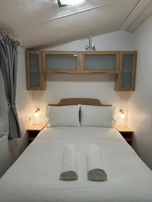 a bedroom with a bed with two towels on it at Stylish Family Friendly 3-Bed Caravan Escape at Seven Bays Park in St Merryn