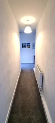 an empty hallway with a white wall and a light at Cornerways, Nr Perranporth in Perranzabuloe