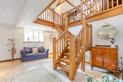 a wooden staircase in a living room with a blue couch at 3 Bed in Gwennap oc-g30876 in Gwennap