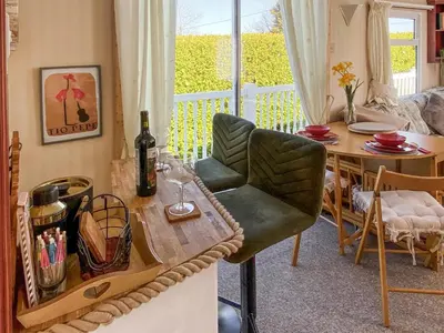 a living room with a table and a chair at Demelzas Retreat in Redruth