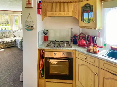 a kitchen with a stove top oven next to a sink at Demelzas Retreat in Redruth