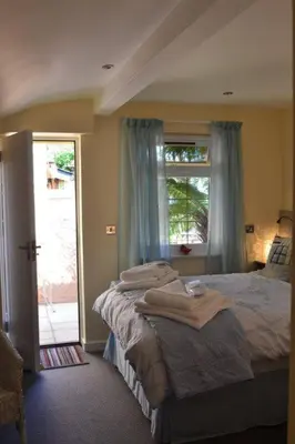 a bedroom with two beds and a large window at Lanteague Cornwall with stunning Sea Views in Gillan