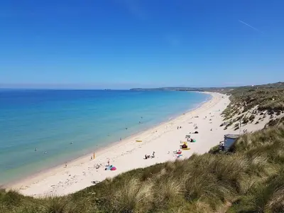 a group of people on a beach near the ocean at Ground Floor Chyreene in Phillack