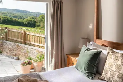 a bedroom with a bed and a window with a view at Riverside cottage on private wildlife estate 1-bed in Washaway