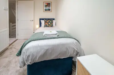 a bedroom with a bed with a green blanket at KAOLIN Splendid Cornwall Home By STAE Homes in St Austell