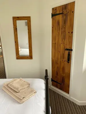 a bedroom with a bed with a mirror and a door at Wheal Rock - Luxury 2 Bed Lodge in St. Agnes