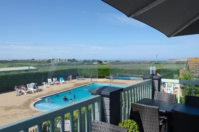 a view of a swimming pool from a balcony at Meadow & Tide in St Merryn