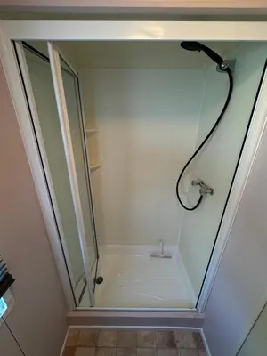 a shower with a glass door in a bathroom at Meadow & Tide in St Merryn