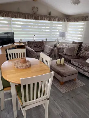 a living room with a table and a couch at Meadow & Tide in St Merryn