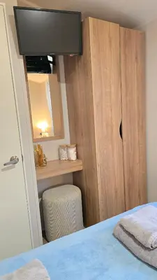 a bedroom with a bed with a television on a cabinet at Cornwall Caravan Retreat 3 Crantock in Crantock