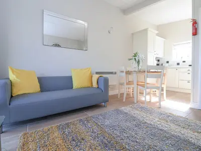 a living room with a blue couch and a table at Atlantic Escape in Bude