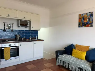 a kitchen with a couch and a kitchen with a stove at 'Rocks' Sea Views with free parking in St Ives in St Ives