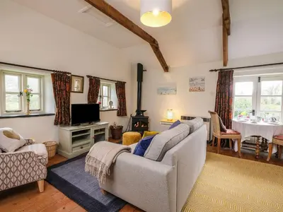 a living room with a couch and a tv at The Mill in Lostwithiel