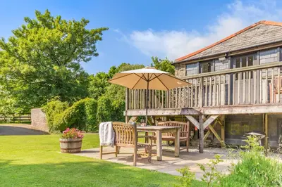 a patio with an umbrella and a table and chairs at 2 Bed in Launceston oc-t31002 in Lewannick