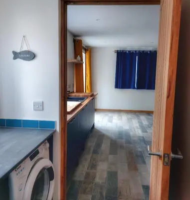 a laundry room with a washing machine in a house at Heart of Kernow Holiday Home in Bugle