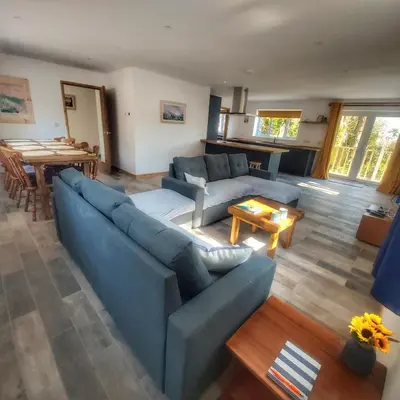 a living room with a blue couch and a table at Heart of Kernow Holiday Home in Bugle
