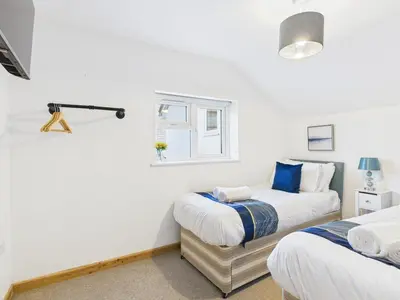 a bedroom with two beds and a window at Surf View by Signature Stays - Pool - Beach Access in Crantock