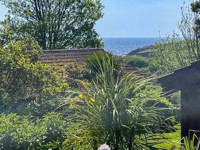 a garden with a view of the ocean at The Hut Hotel in Falmouth