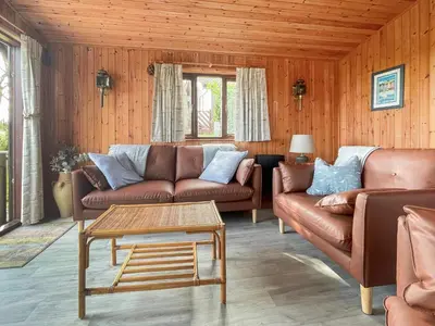 a living room with leather couches and a coffee table at The Hut Hotel in Falmouth
