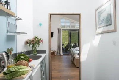 a kitchen with a sink and a counter with vegetables on it at The Perch Studio in Polzeath