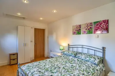 a bedroom with a bed and two paintings on the wall at Finest Retreats - Jubilee Cottage at Bodmin Moor in Saint Breward