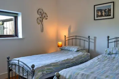 two beds sitting next to each other in a bedroom at Finest Retreats - Jubilee Barn Cottage at Bodmin Moor in Saint Breward