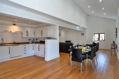 a kitchen and living room with a table and chairs at Finest Retreats - Jubilee Barn Cottage at Bodmin Moor in Saint Breward
