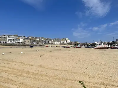 a sandy beach with buildings in the background at 3 Sunnyside - amazing harbour views in St Ives