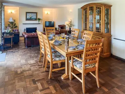 a dining room with a wooden table and chairs at Riverside in Truro