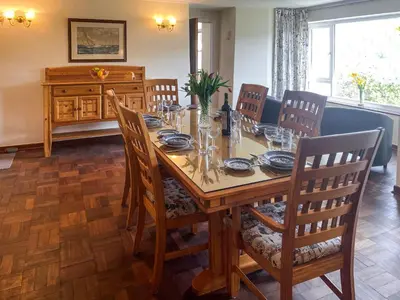 a dining room with a wooden table and chairs at Riverside in Truro