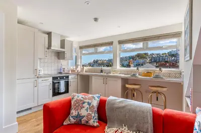 a living room with a red couch in a kitchen at High Tide Bedford Rd Boutiques in St Ives