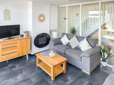 a living room with a couch and a coffee table at Stunning Sea View Apartment in Newquay with 2 Heated Pools in Crantock