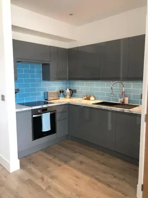 a kitchen with gray cabinets and blue tiles at Dixies View - 2 bed apartment - Central St Ives in St Ives