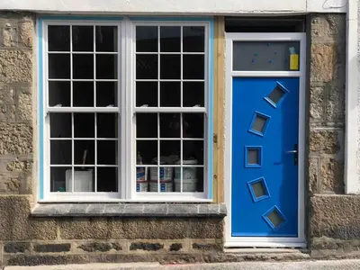a blue door and a window on a brick building at Dixies View - 2 bed apartment - Central St Ives in St Ives