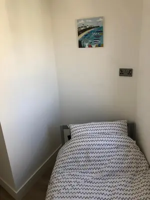 a bedroom with a bed with a picture on the wall at Dixies View - 2 bed apartment - Central St Ives in St Ives