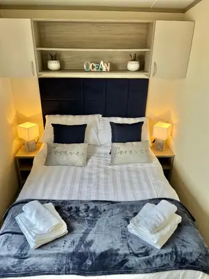 a bedroom with a large bed with two pillows at Sea Breeze Escape in Cubert