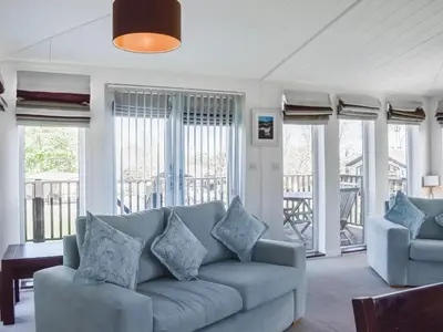 a living room with a couch and two chairs at Sunshine Lodge in Polperro