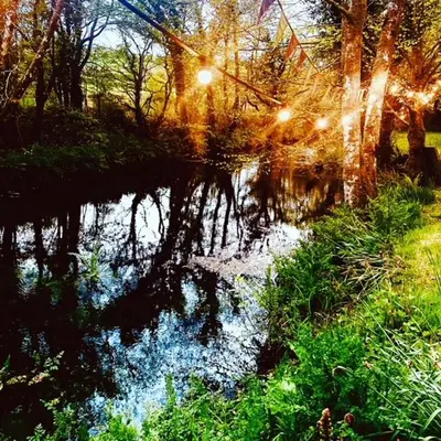 a reflection of the sun in a body of water at Dowr-Gwel Shepherds Hut in Saint Cleer