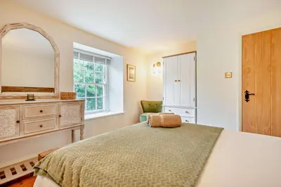 a bedroom with a bed and a mirror and a chair at 3 Bed in Penryn oc-chy969 in Penryn