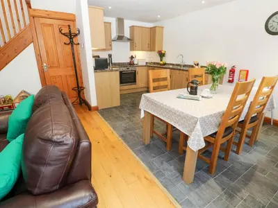 a kitchen and dining room with a table and a couch at The Stable Barn in Hayle